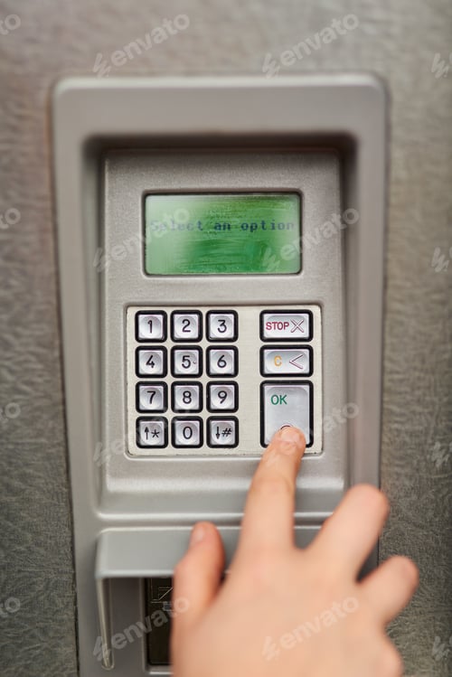 Preview: Keeping his pin code a secret. Cropped view of a male hand using an ATM.