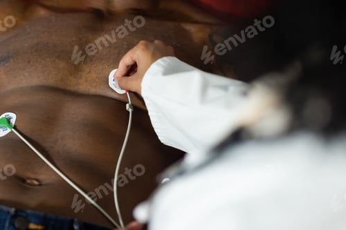 Preview: Midsection of biracial female doctor examinating african american male patient, doing ecg test