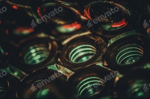 Preview: Closeup shot of small metal screw nuts in a dark atmosphere