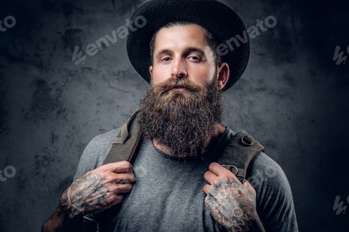 Preview: Bearded tattooed male in a hat