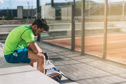 Preview: Padel player sitting on the floor resting