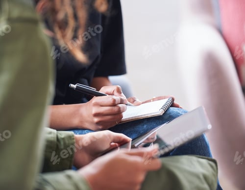 Preview: African american woman writing notes with friend showing ideas on digital tablet computer students