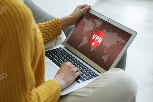 Preview: Woman using laptop with switched on VPN indoors, closeup