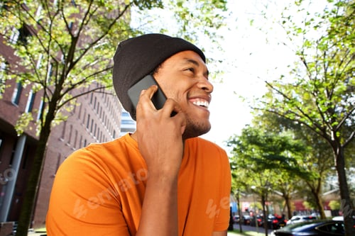 Preview: Close up happy african american man talking with mobile phone in city