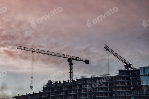 Preview: Construction cranes work on creation site against sky background