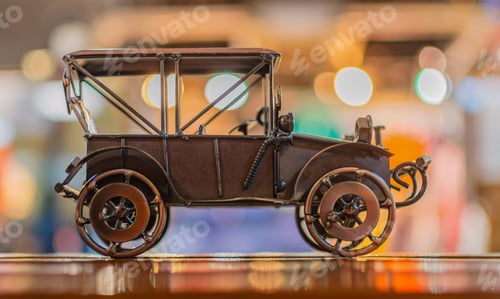 Preview: Bronze model toy retro car stands on a wooden surface on an abstract background