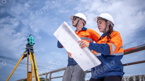 Preview: Engineers Surveyor wearing safety uniform ,helmet with equipment theodolite to measurement positioni