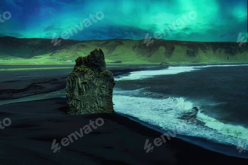 Preview: Scenery of Aurora borealis glowing over Kirkjufjara black sand beach with eagle rock