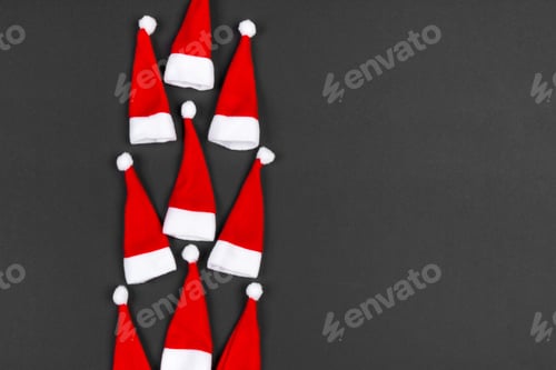 Preview: Top view of colorful holiday background made of Santa hats. Merry Christmas concept with copy space