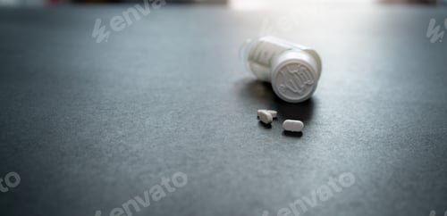 Preview: White tablets pills and blur child-resistant pill bottle on black table. Prescription drugs. Pharmac