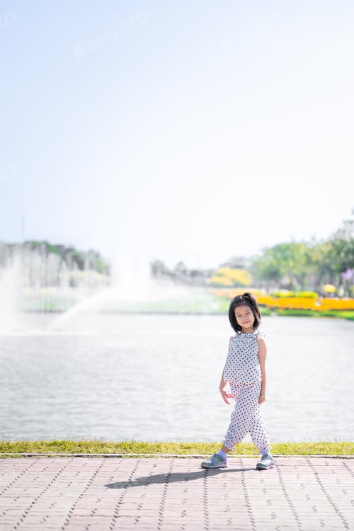 Preview: Girl in Polka Dots Walking by Sunny Waterfront, Kid takes graceful walk along the waterfront.