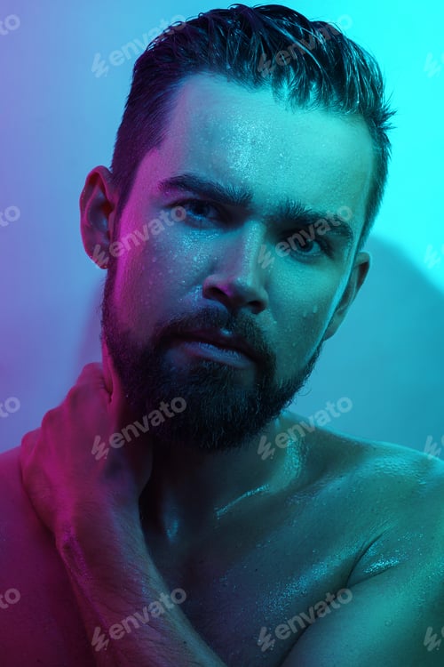 Preview: Handsome young man with wet skin in neon light