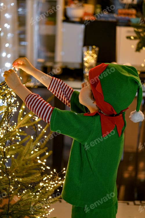 Preview: Two little kids wearing masquerade costumes decorating Christmas tree at home.