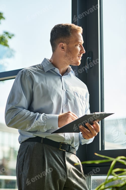 Preview: Handsome young businessman reflecting on opportunities while working in modern office
