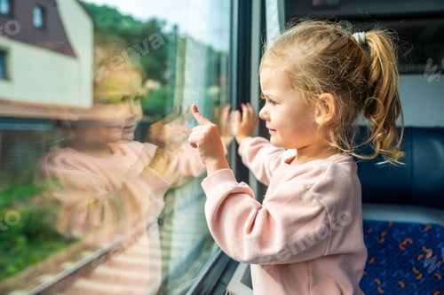 Preview: Beautiful little girl looking out train window outside, while it moving. Traveling by railway in