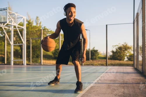 Preview: black man doing sports, playing basketball on sunrise, active lifestyle, sunny summer morning