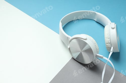 Preview: White, over-the-ear headphones with a wire on a blue background.