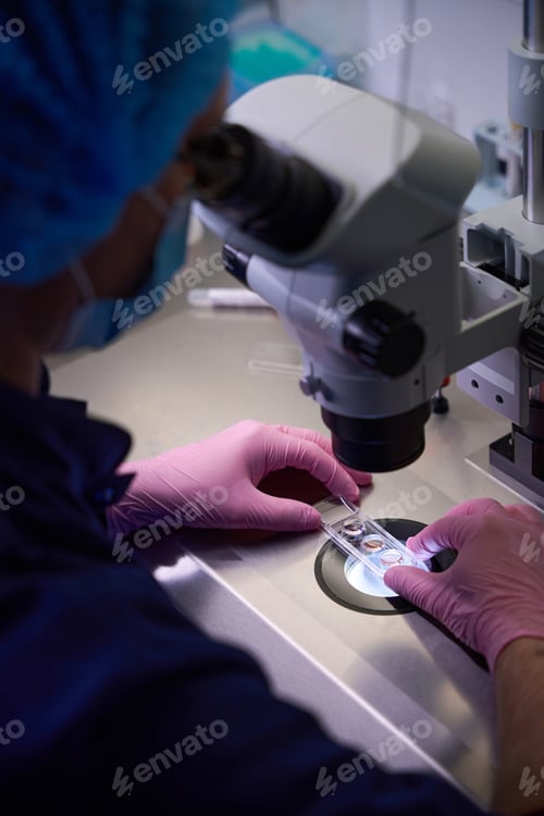 Preview: Doctor positioning a sample under a microscope for analysis