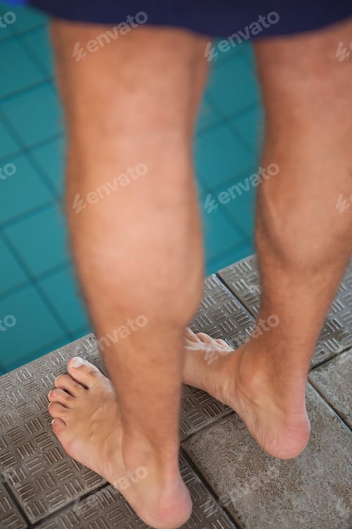 Preview: Close up low section of swimmer standing by the pool at leisure center