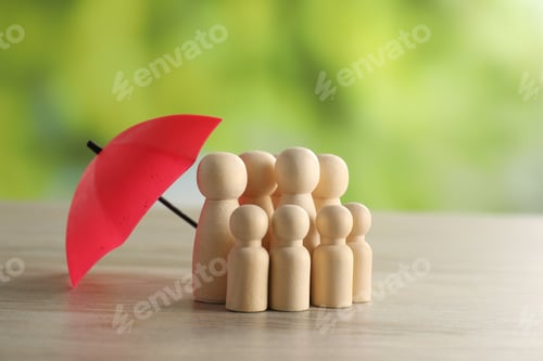 Preview: Human figures under umbrella on light wooden table outdoors. Insurance concept