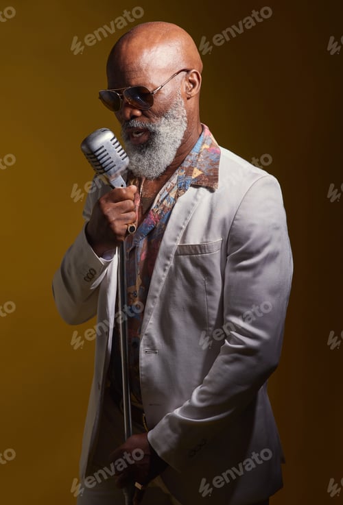 Preview: Studio shot of a senior man wearing vintage clothes while singing into a microphone