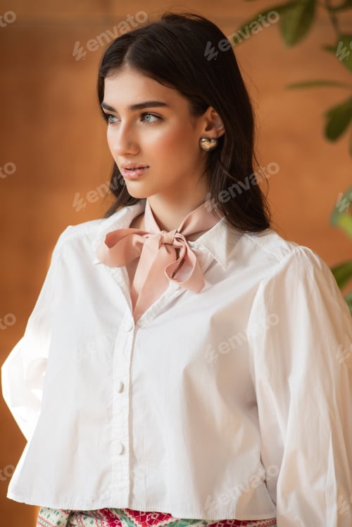 Preview: Casual woman sitting on a sunny wall