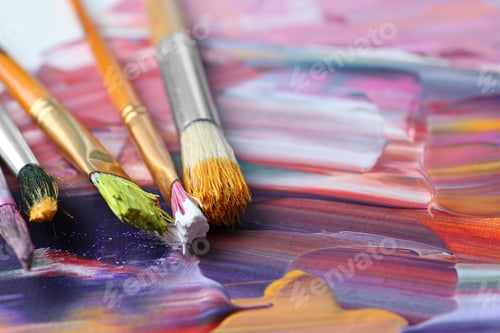 Preview: Set of different brushes on abstract colorful paint, closeup