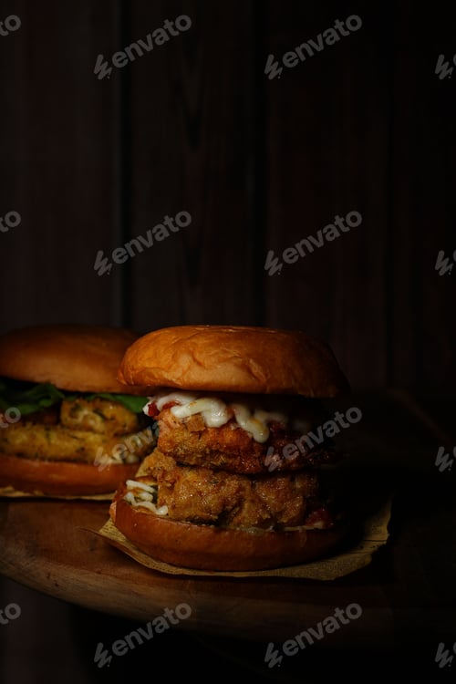 Preview: Classical burgers on wooden table with dark background