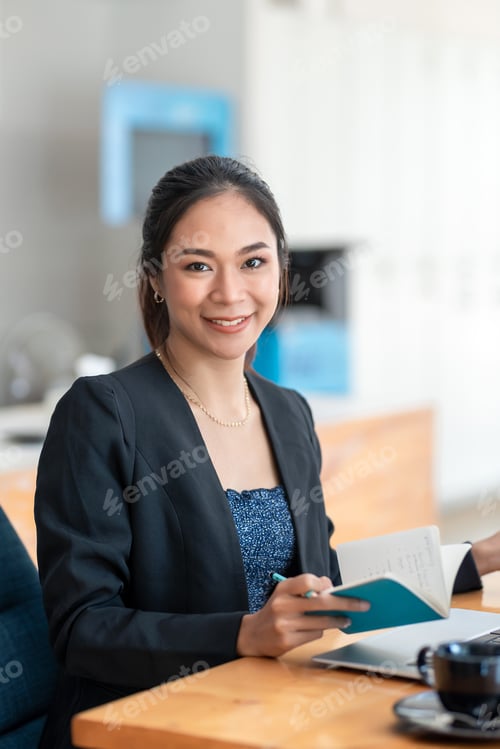 Preview: Asian businesswoman Sitting in the office chair holding a document and Looking at camera.