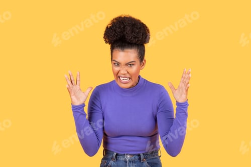 Preview: Young Brazilian woman expressing strong emotions against a yellow background