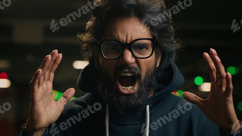 Preview: Close up angry mad aggressive Arabian bearded man in glasses scream at dark parking portrait furious