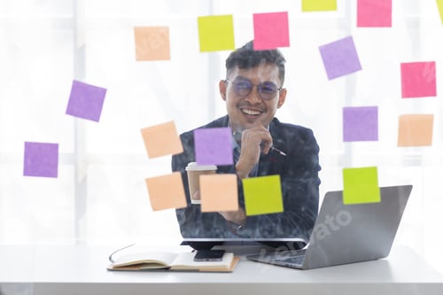 Preview: Concentrated adult business asian man, organizing his busy work week in the office. documents money