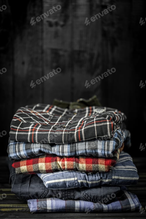Preview: Stack of Flannel Shirts on Wood Surface
