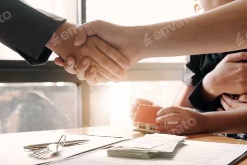 Preview: Estate agent shaking hands with his customer after contract signature, Contract document and house