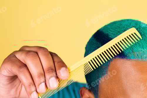 Preview: Black african man in casual on yellow background blue bright hair brushing, beauty salon concept