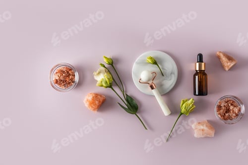 Preview: rose quartz roller massager, cosmetic massage oil bottle, bath salt. Top view. Flat lay.