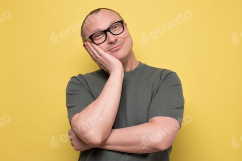 Preview: Young handsome man with glasses thinking or dreaming about future.