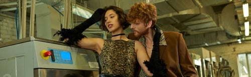 Preview: trendy man flirting with pretty asian girlfriend in dress in coin laundry, banner