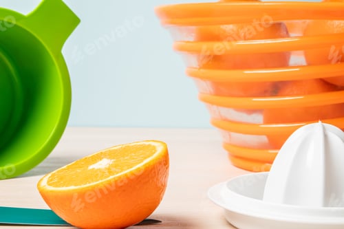 Preview: Closeup shot of a freshly cut orange next to a juicer