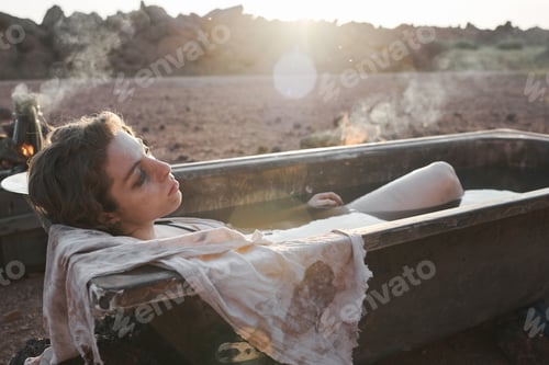Preview: Woman lying in the bath in the desert