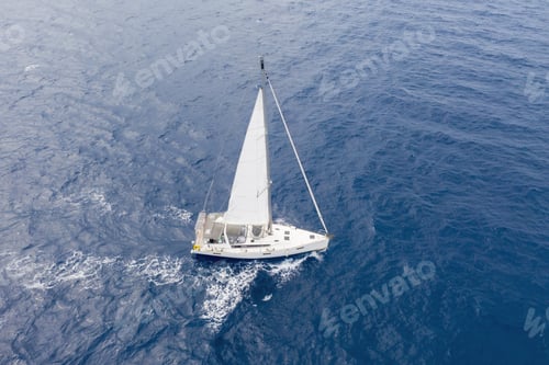Preview: Sailing boat with white sails, rippled sea background