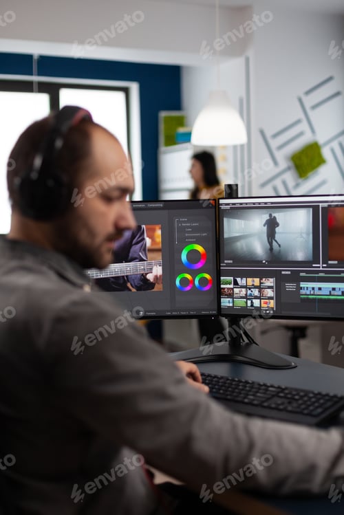 Preview: Video maker with headset working with footage and sound on pc with two displays