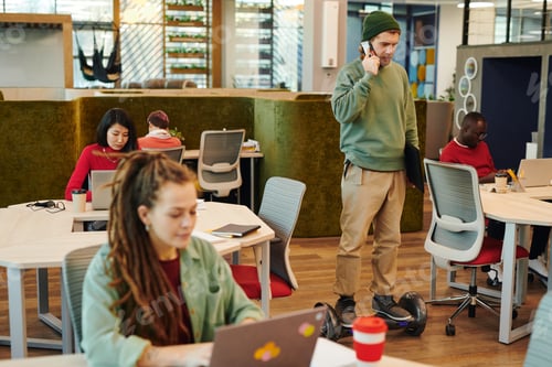 Preview: Young contemporary businessman on gyroscope moving along large open space office