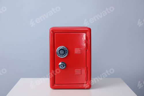 Preview: Red steel safe on white table against light grey background