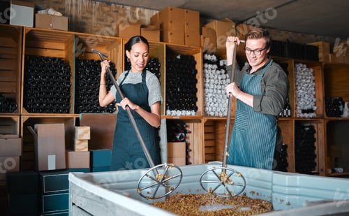 Preview: Winemakers mixing and shaking grapes during the wine making process inside of a distillery. Cellar