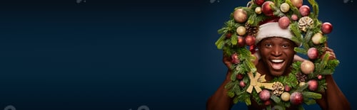 Preview: portrait of cheerful american man in santa hat and christmas wreath on dark blue backdrop, banner