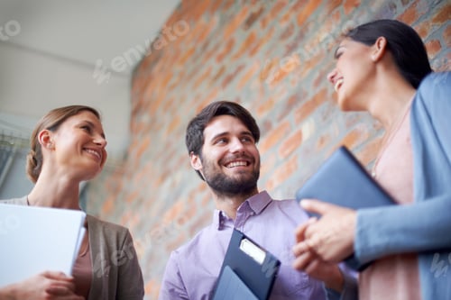 Preview: Catching up before the meeting. Shot of a coworkers talking to each other in a office hallway.