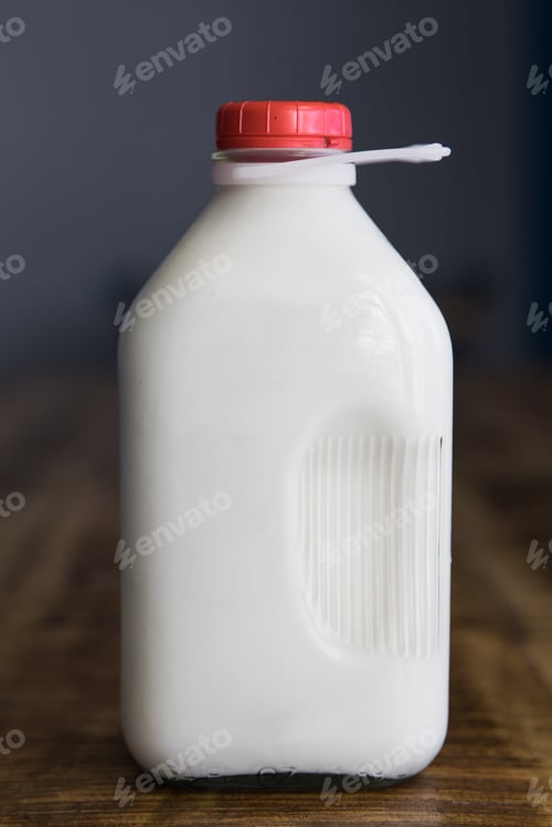 Preview: Vertical shot of an unlabeled glass jug of milk on the table