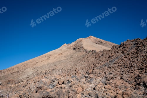 Preview: some very rocky and barren hills on a clear day with a blue sky