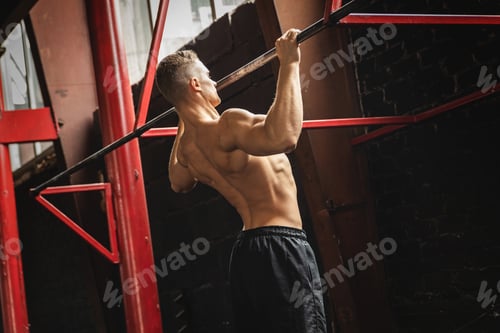 Preview: Strong man doing pull up exercise in the gym